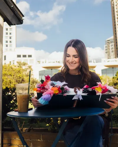 Michelle Ruiz en una mesa de café al aire libre, con un café frío y su Biblia.