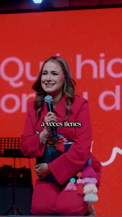 Michelle Ruiz hablando en el escenario con el micrófono en la mano.